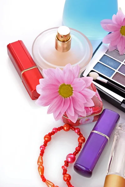 Beaucoup de cosmétiques colorés pour femme avec fleur sur fond blanc — Photo