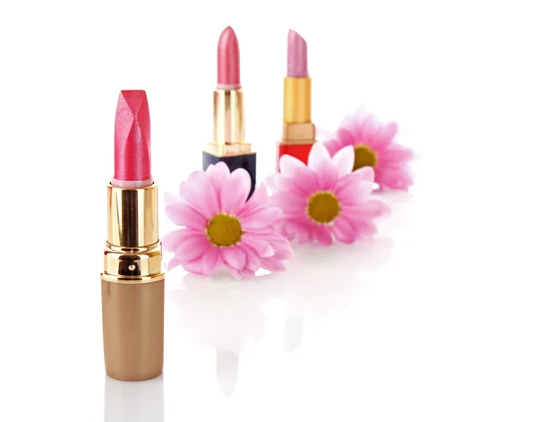 Nya läppstift på kosmetika och blomma bakgrund — Stockfoto