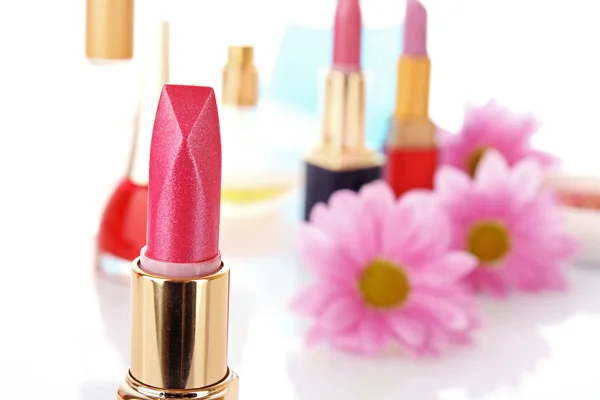 Nouveau rouge à lèvres sur fond cosmétique et fleur — Photo