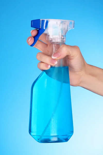 Hände mit Spray auf blauem Hintergrund — Stockfoto