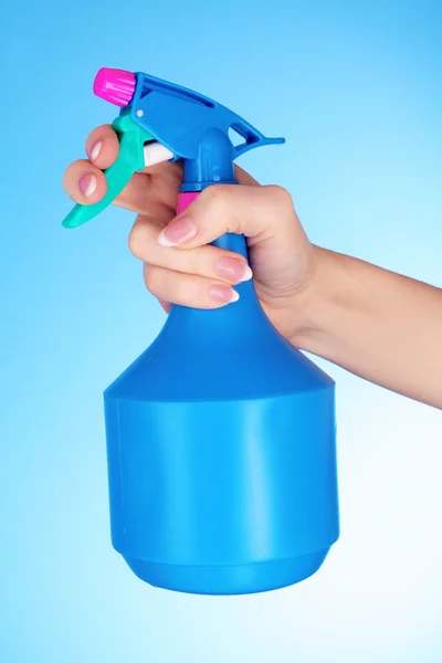 Ręce z spray na niebieskim tle — Zdjęcie stockowe