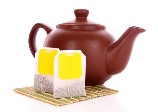 Primo piano della bustina di tè e teiera isolato su sfondo bianco — Foto Stock