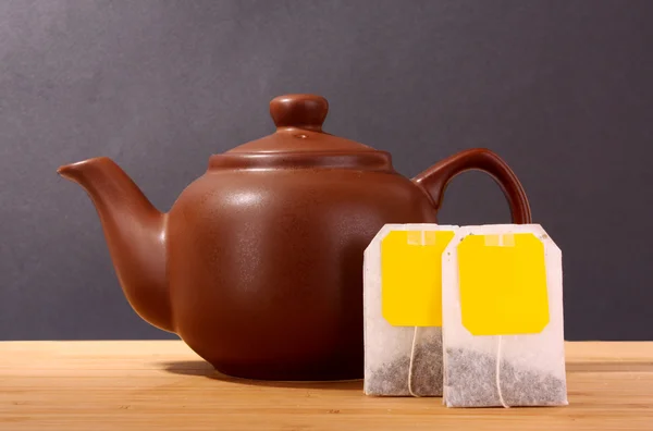 Крупним планом чайний пакет і чайник ізольовані на білому тлі — стокове фото