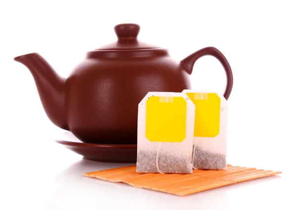 Close-up of tea bag and teapot isolated on white background — Stock Photo, Image