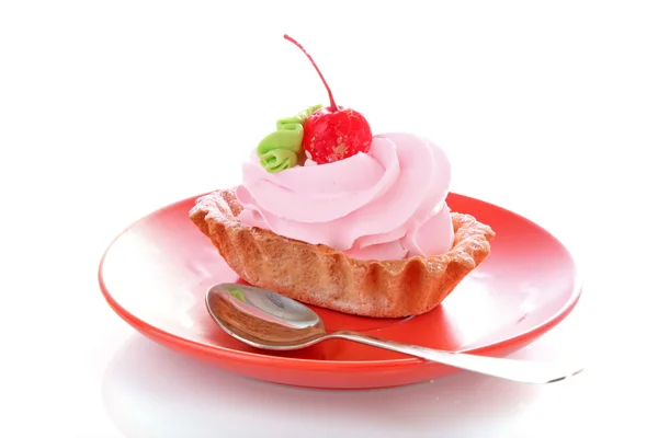 Rosa cheesecake med maraschino körsbär på plattan — Stockfoto