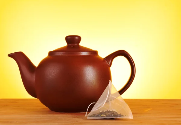 stock image Close-up of tea bag and teapot on yellow background