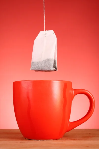 Nahaufnahme von Tee und Tasse auf rotem Hintergrund — Stockfoto