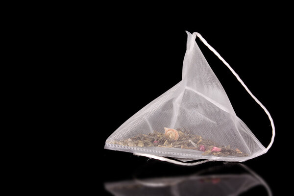 Крупный план чайного пакетика на черном фоне
