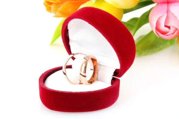 Свадебные кольца и букет цветов на белом — стоковое фото