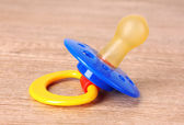 Baby silicone pacifier in blue, red and yellow colors, isolated
