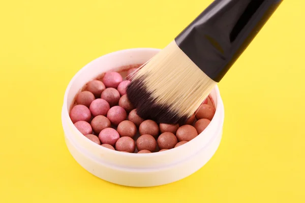 Kosmetikpinsel und Rouge auf gelbem Hintergrund — Stockfoto