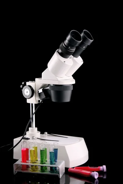 Microscope en métal de laboratoire et éprouvettes avec liquide sur le b — Photo