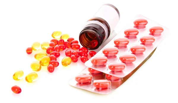 Rote Kapseln mit Vitaminen auf weißem Hintergrund — Stockfoto