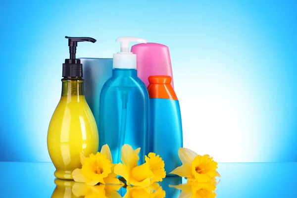 Flaskor av skönhet och hälsa produkter på blå bakgrund med re — Stockfoto