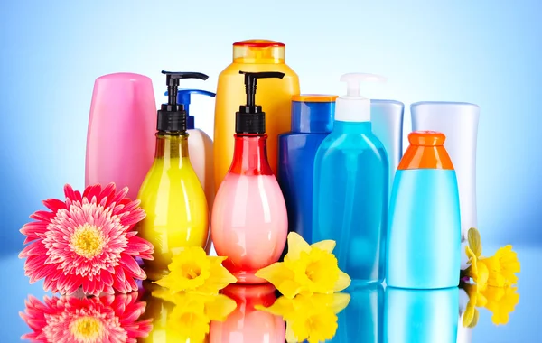 Botellas de productos de salud y belleza sobre fondo azul con re — Foto de Stock