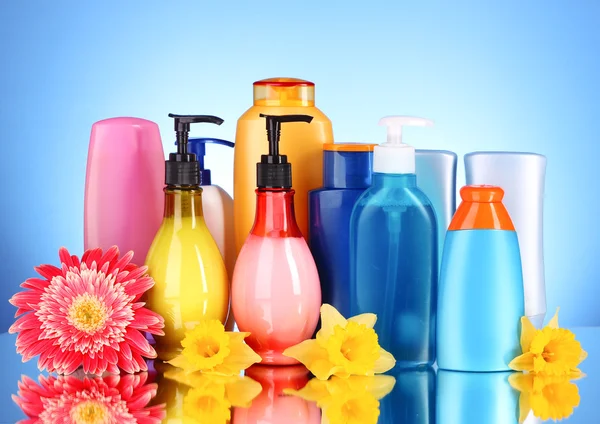 Bottiglie di prodotti di salute e bellezza su sfondo blu con re — Foto Stock
