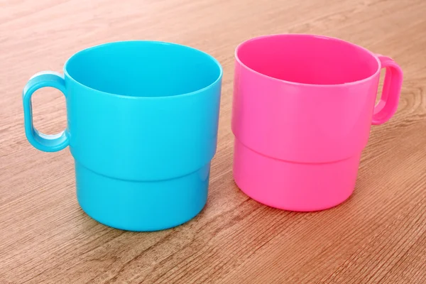 Пластиковые чашки цвета на столе — стоковое фото