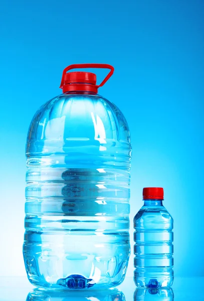 Бутылки воды на синем фоне — стоковое фото