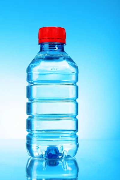 Flasche Wasser auf blauem Hintergrund — Stockfoto
