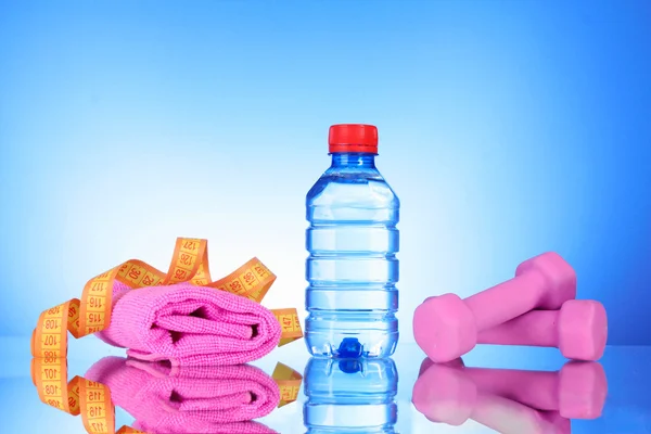 Hanteln und Flasche Frischwasser auf blau — Stockfoto