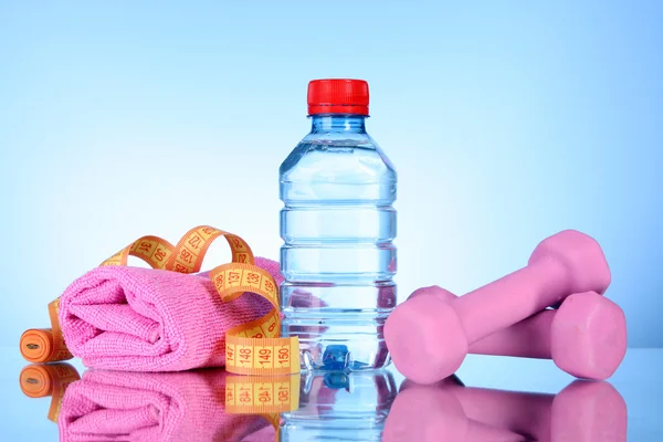 Dumbbells and bottle of fresh water on blue — Stock Photo, Image