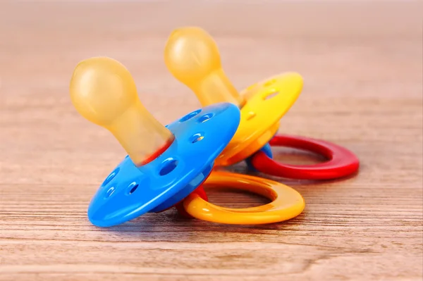 Ciuccio in silicone per bambini nei colori blu, rosso e giallo, isolato — Foto Stock