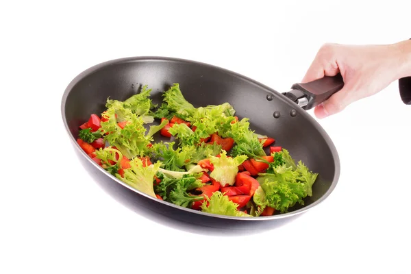 Frying pan with vegetables in hand on white — Stock Photo, Image