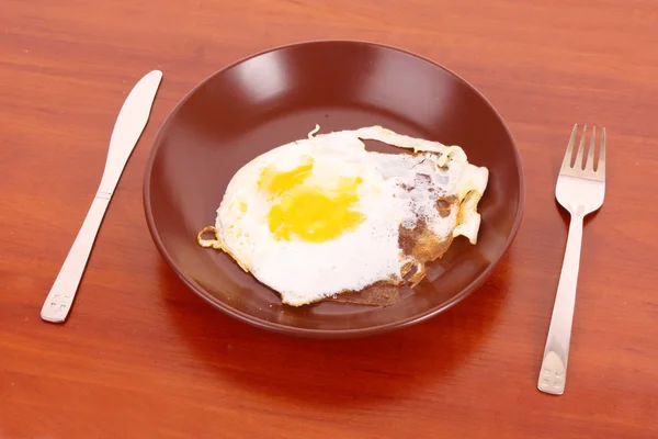 stock image Frying egg with fork and knife on the table