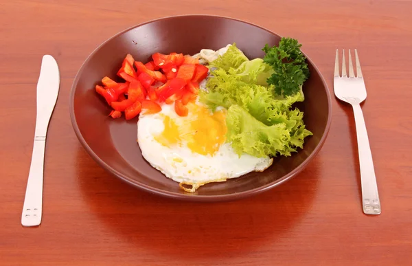 Smažení vajec s vidličkou a nožem na stůl — Stock fotografie