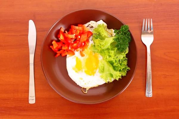 Smažení vajec s vidličkou a nožem na stůl — Stock fotografie