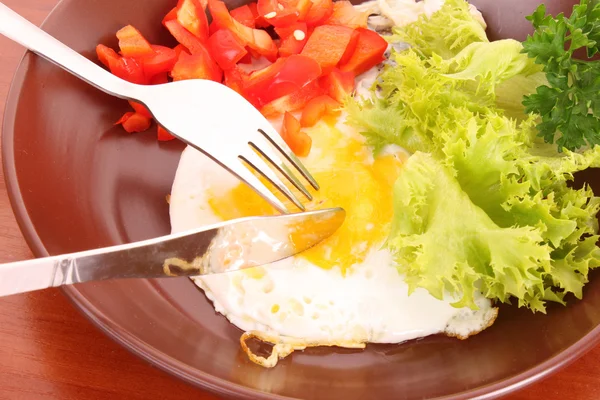 Смажити яйце з виделкою і ножем на столі — стокове фото