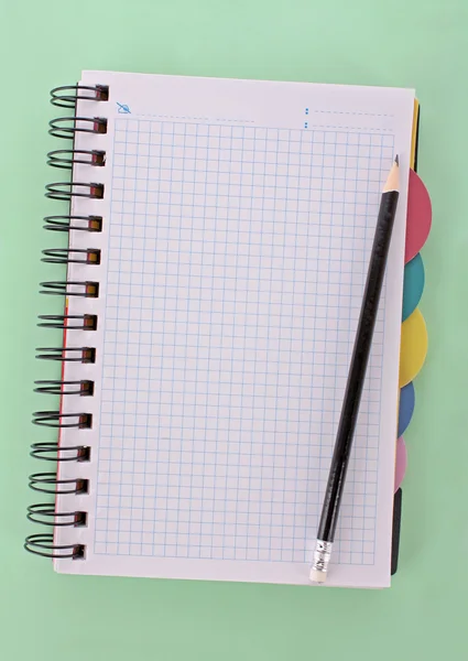 Cuaderno con lápiz sobre el fondo verde — Foto de Stock