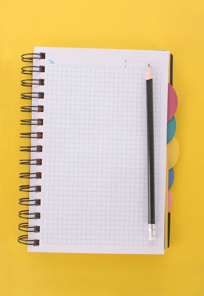 Notatnik z ołówkiem na żółtym tle — Zdjęcie stockowe