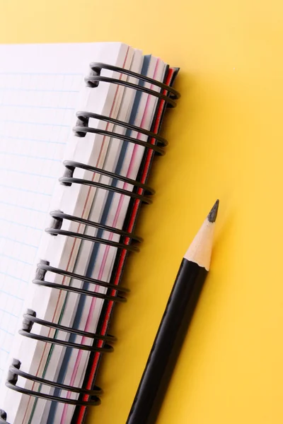 Sarı arkaplanda kurşun kalem olan defter — Stok fotoğraf