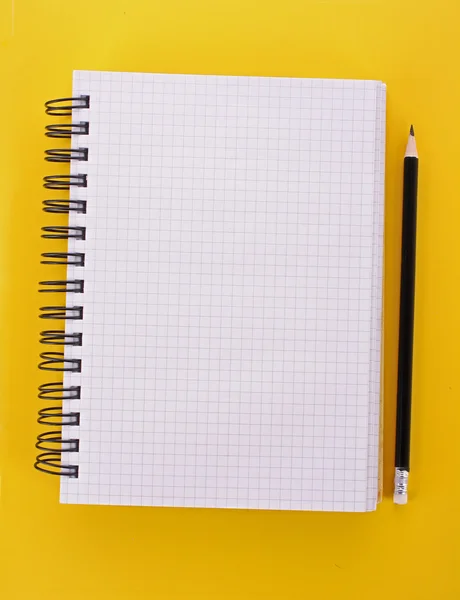 Notatnik z ołówkiem na żółtym tle — Zdjęcie stockowe