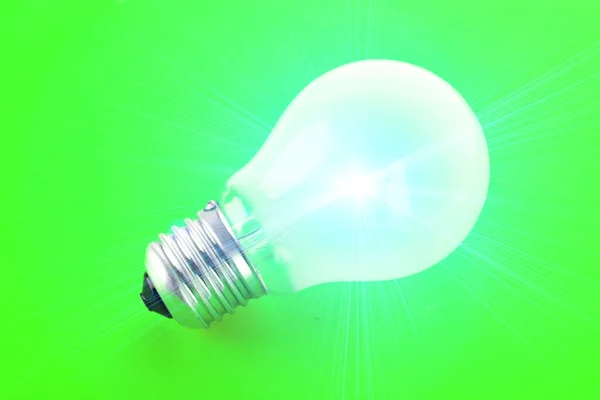 stock image Light bulb on green background