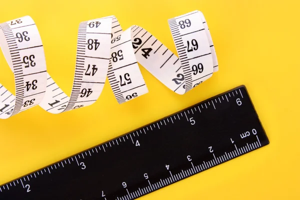 Tape measure and ruler on yellow background — Stock Photo, Image