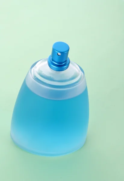 Flacon de parfum bleu avec gouttes d'eau fond bleu — Photo