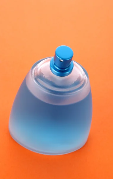 Modré parfémy láhev s oranžové pozadí — Stock fotografie