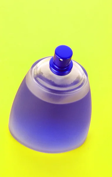 Frasco de perfume azul con fondo naranja — Foto de Stock