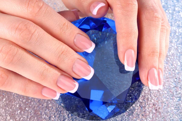 Piękna kobieta ręce z Francuski manicure na niebieskim tle — Zdjęcie stockowe