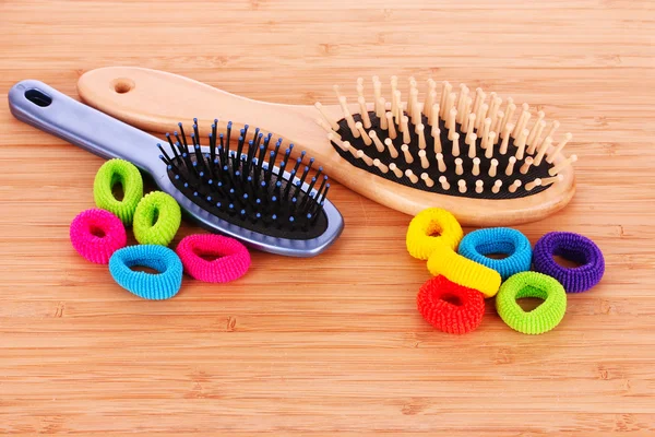 Escova de cabelo e scrunchies de cabelo no fundo marrom — Fotografia de Stock