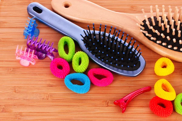 Escova de cabelo e scrunchies de cabelo no fundo marrom — Fotografia de Stock