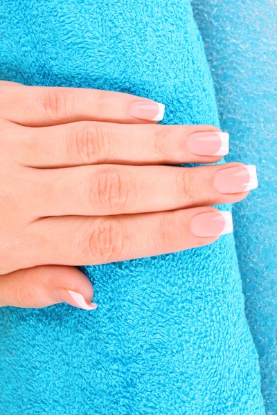 Beautiful woman hands with french manicure on blue background — Stock Photo, Image