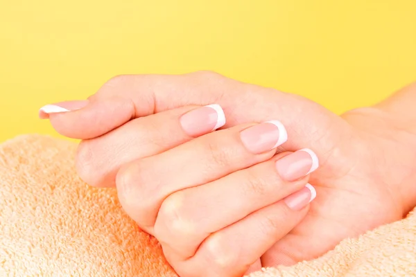 Belas mãos de mulher com manicure francês no fundo amarelo — Fotografia de Stock