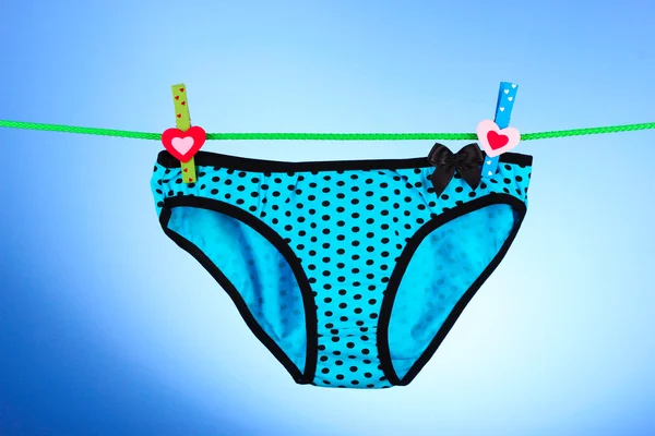 Woman's panties hanging on blue background — Stock Photo, Image