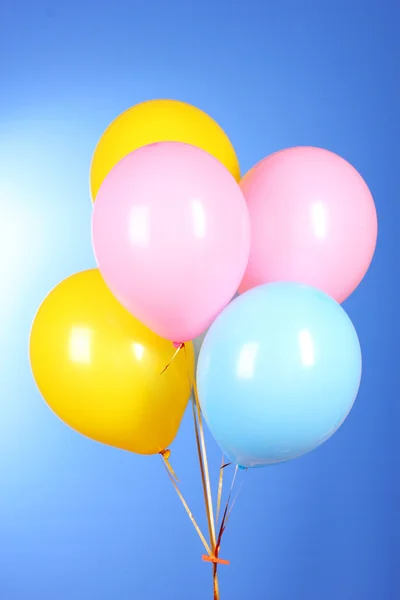 Balões voadores em um fundo azul — Fotografia de Stock