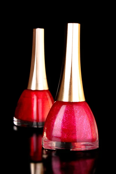Esmalte de uñas rosa sobre fondo negro — Foto de Stock