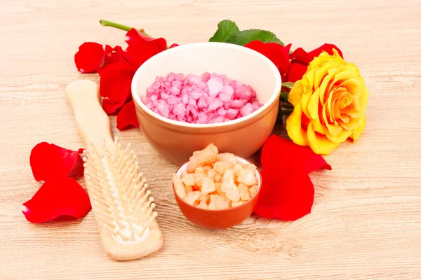 Koupelová sůl z aromatických, kartáč na vlasy růže a lístky na dřevěných backg — Stock fotografie