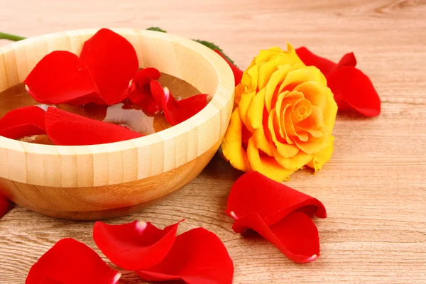 Красные лепестки роз внутри и вокруг чаши с водой — стоковое фото